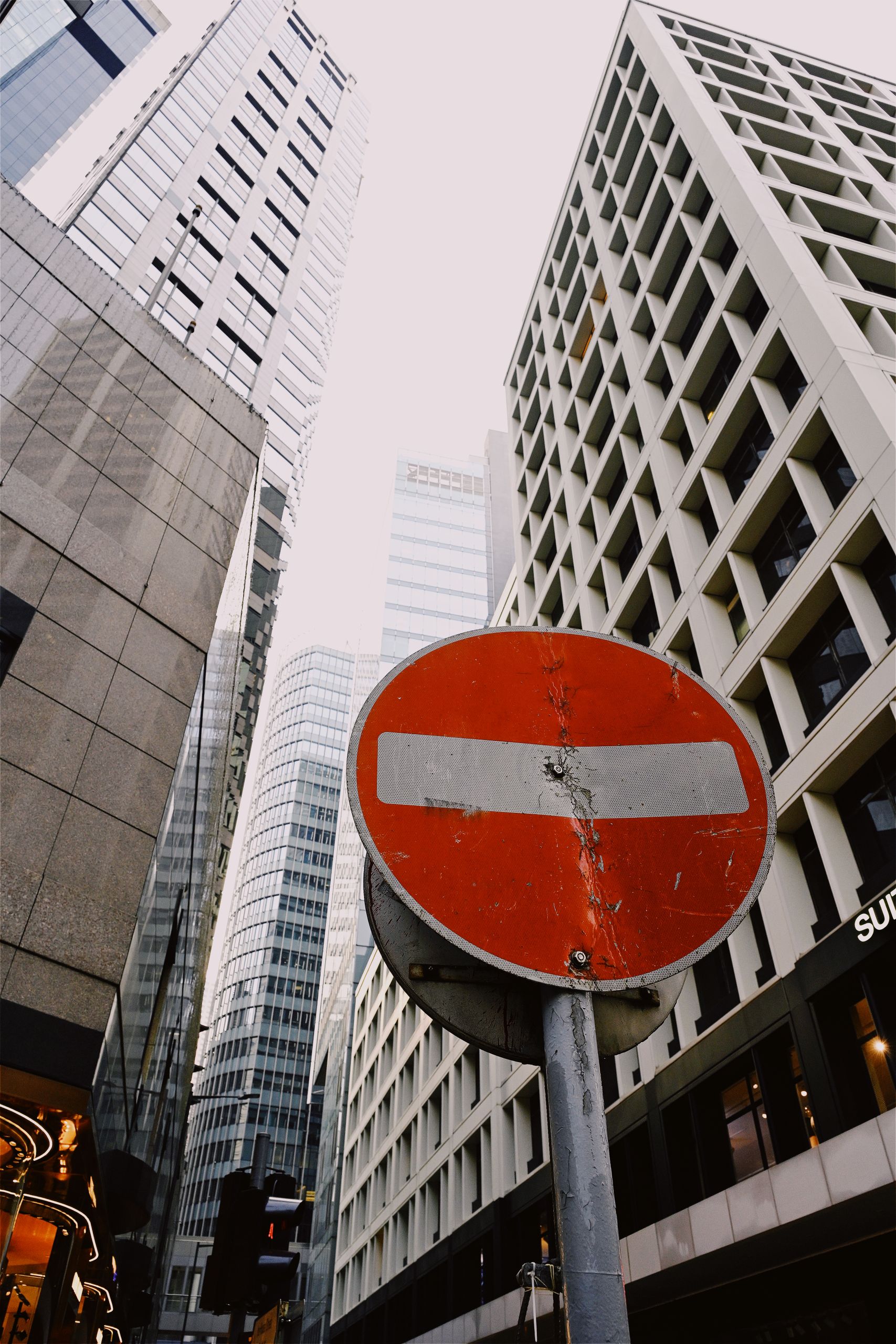 A vibrant urban scene featuring a no entry sign against tall modern skyscrapers.